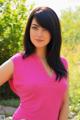 A woman in a pink shirt posing for a picture.